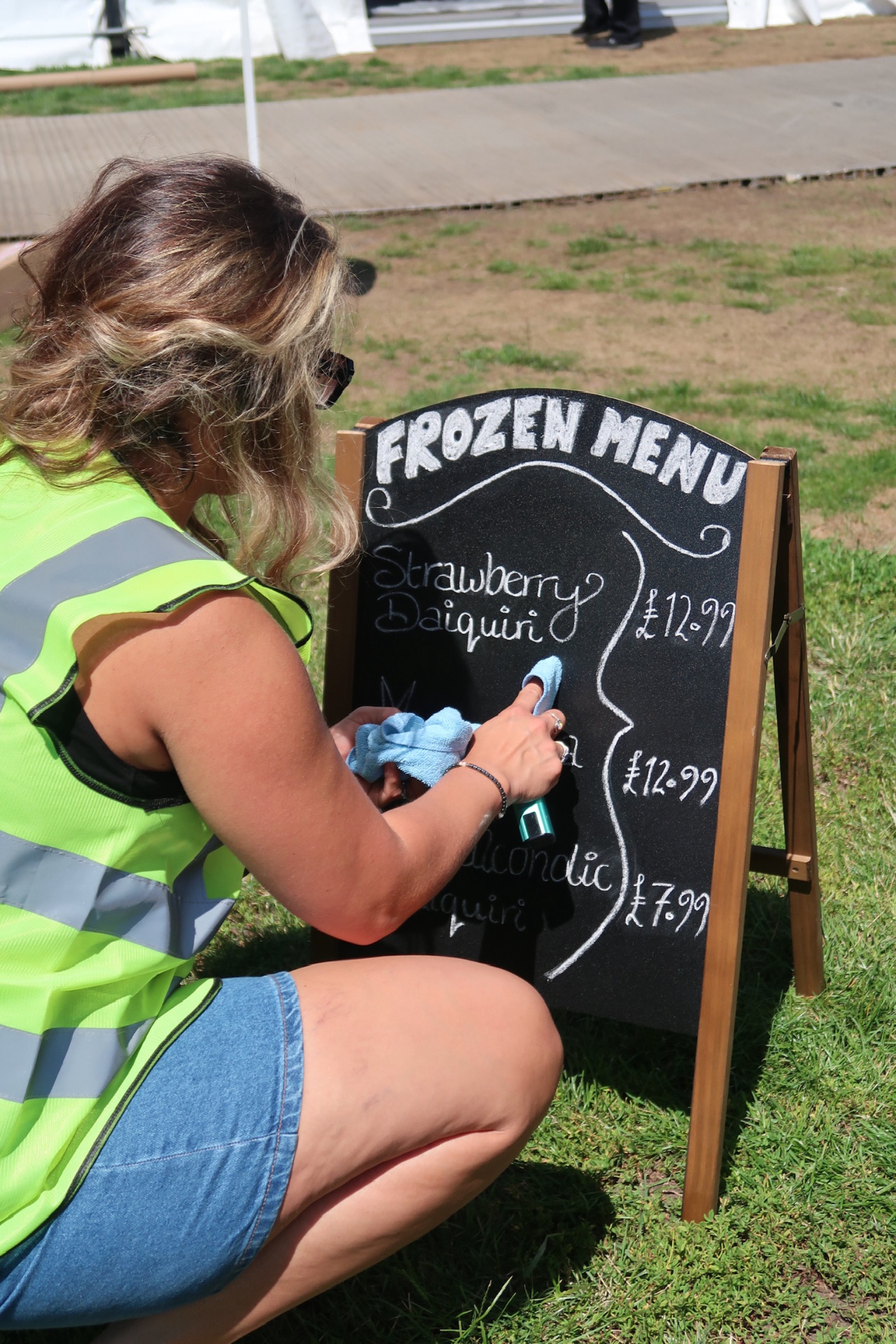Team member chalking up the frozen menu board at setup
