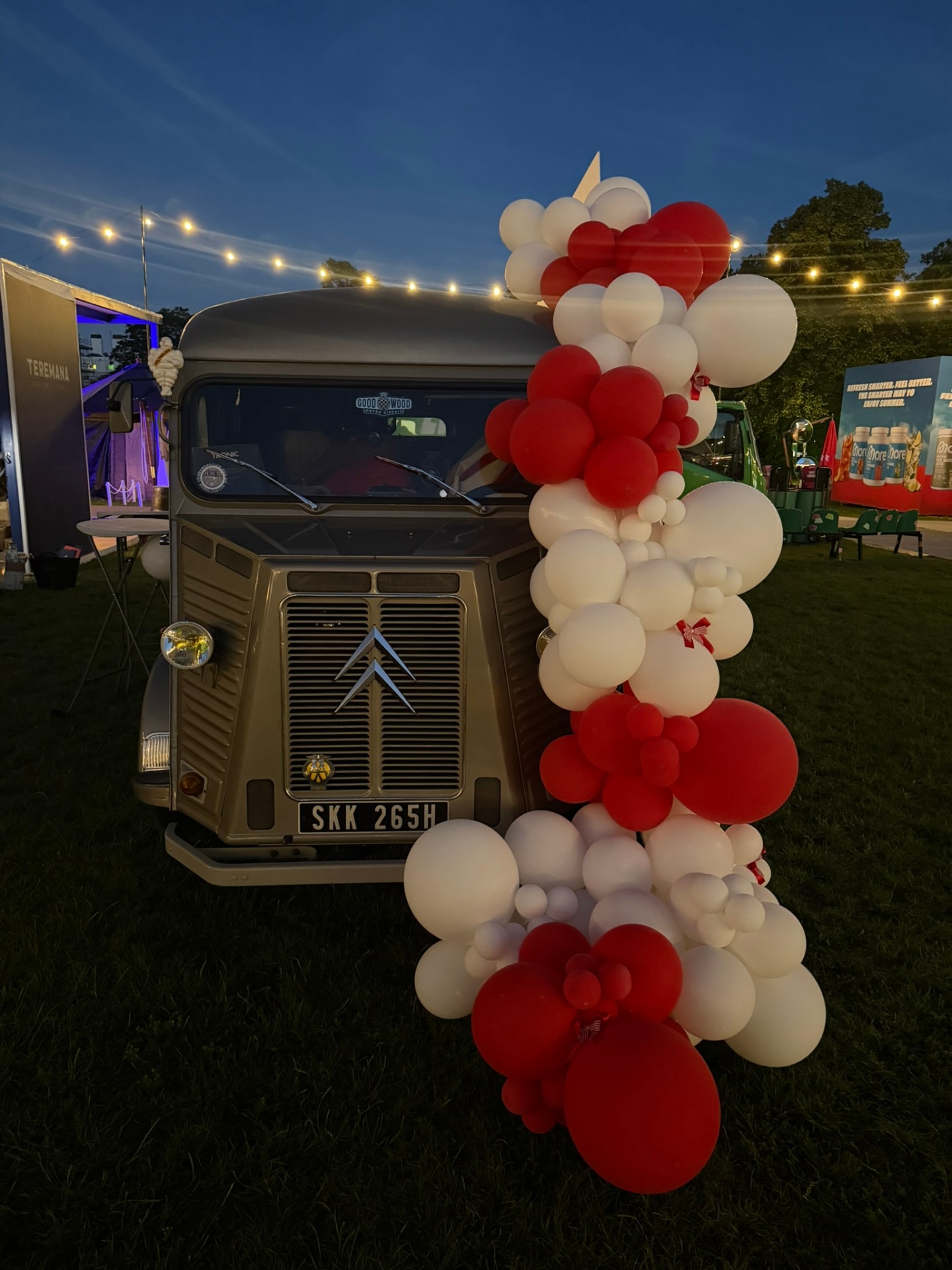 The Daiquiri Club van at night framed by red and white balloon garland and festoon lights