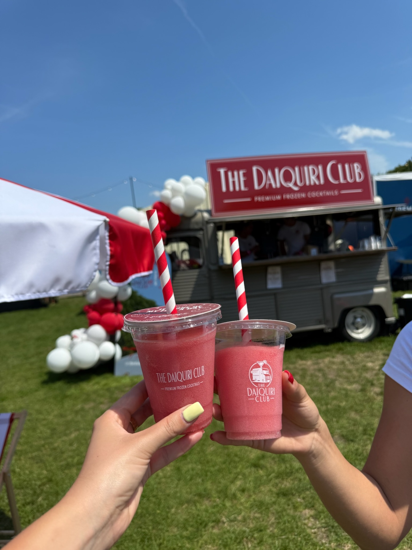 Two strawberry daiquiris cheers in front of The Daiquiri Club van