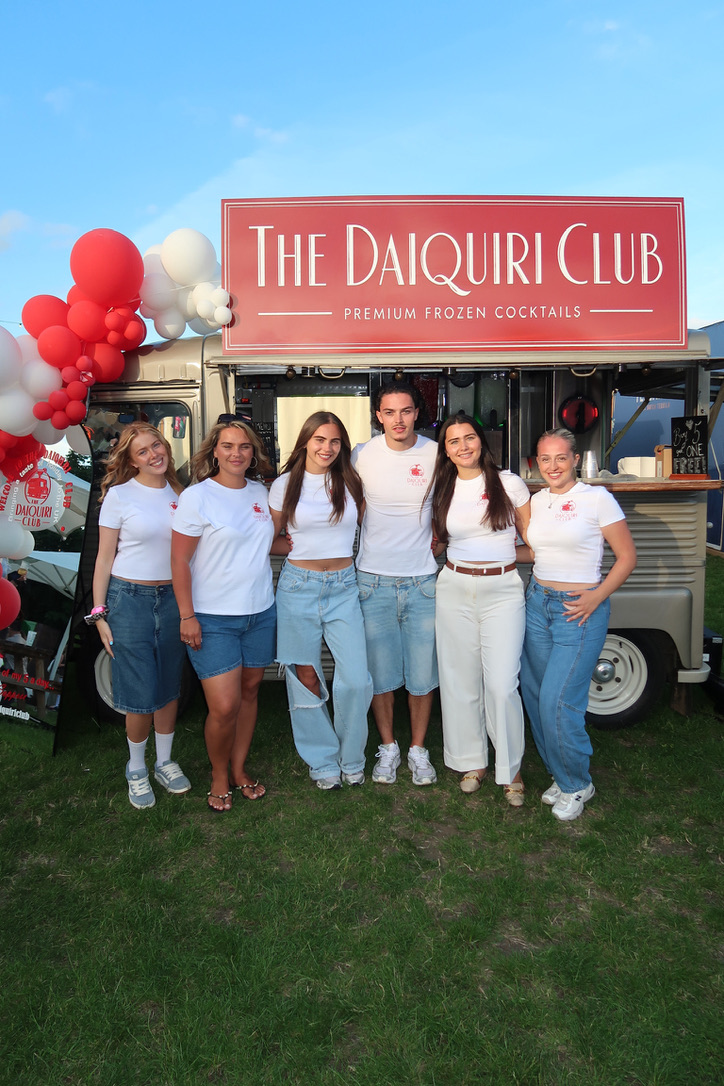 The full Daiquiri Club team posing in front of the van