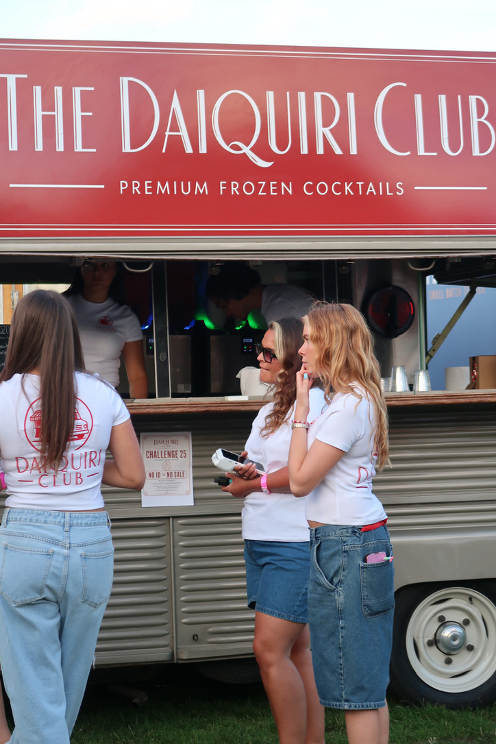 Daiquiri Club staff in branded tees chatting with guests at the van