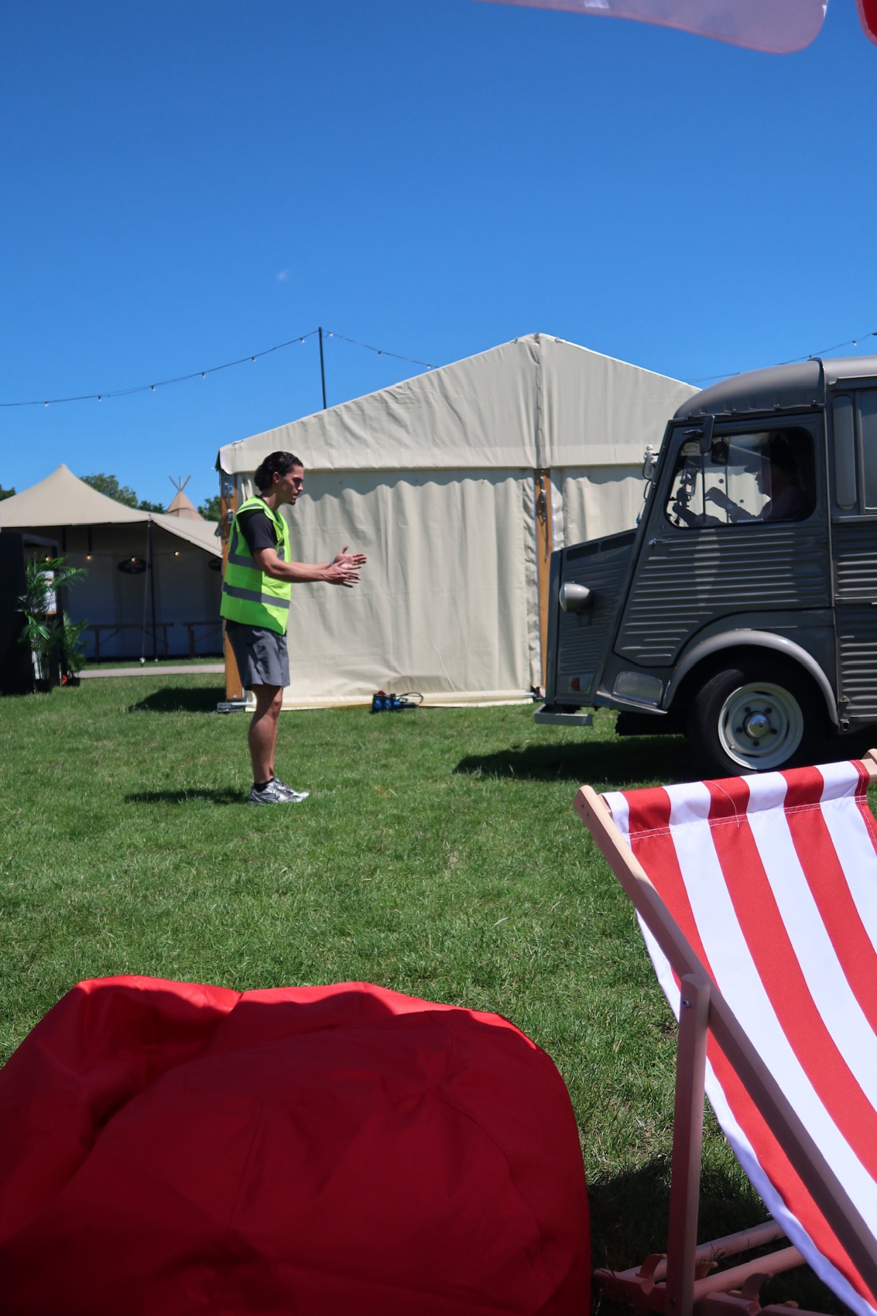 Setting up the van pitch with deckchairs and bean bags on a sunny day